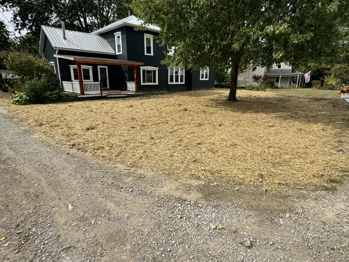 Completed land grading project on a residential property in Marysville, Ohio showing smooth soil contours directing water away from the home