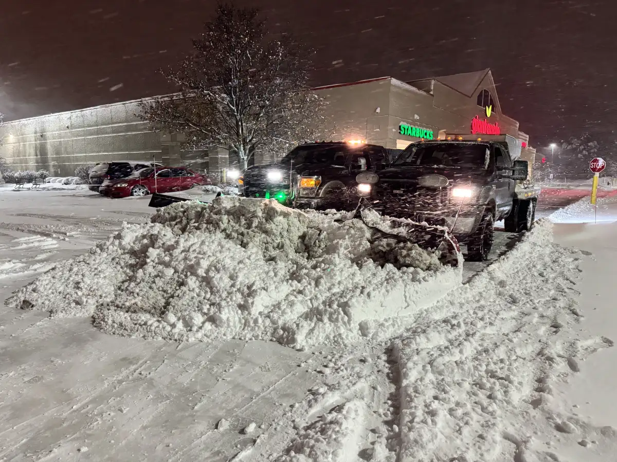 Snow plow clearing a commercial driveway entrance during a winter storm in Union County, Ohio